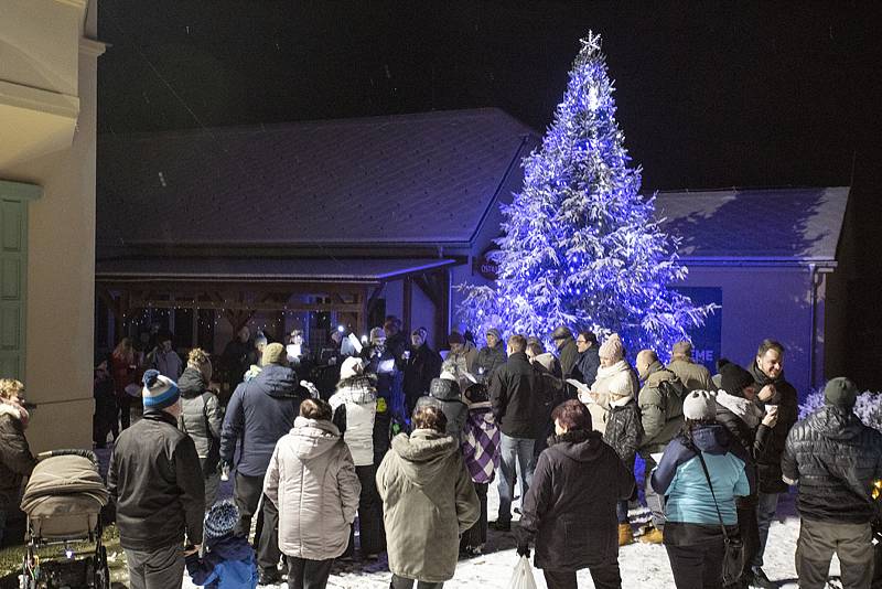 Lichnov zpíval koledy pod zasněženým a svítícím vánočním stromem.