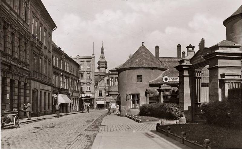 Zámecké náměstí v Krnově. Pamětníci vzpomínají, že vpravo před podloubím byl mléčný bar, kam se chodilo na koktejly, vynikající špičky, gumové hady a další dobroty. Naproti bylo železářství.