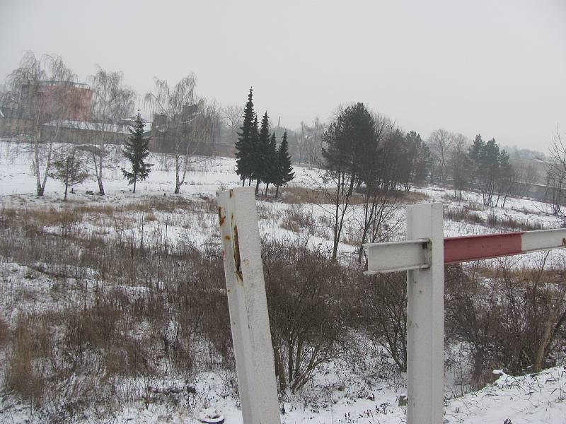 Vedle silnice za zábradlím začíná svah, který patří kraji. Dole pod svahem leží pozemky města.