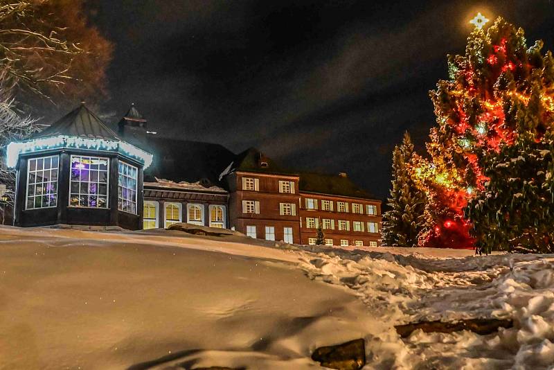 Večerní Karlova Studánka bez lidí a s vánoční nasvícenou atmosférou.