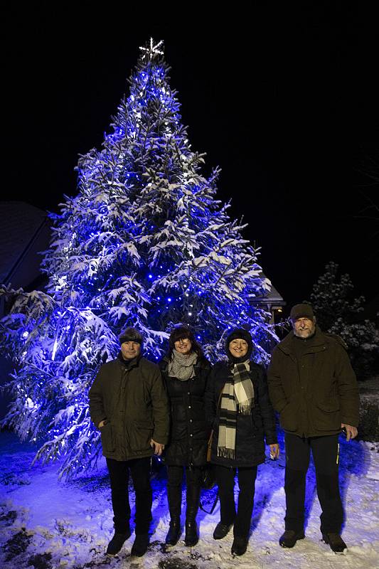 Lichnov zpíval koledy pod zasněženým a svítícím vánočním stromem.