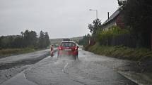 V úseku u Krnova, kde se silnice první třídy změnila ve staveniště obchvatu, musí auta přes "brod" . Naštěstí je brouzdaliště na silnici zatím mělké.