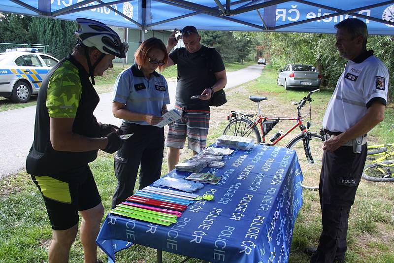 Policisté postavili svůj infostánek na cyklostezce z Krnova do Opavy.  V rámci akce  „Na kole jen s přilbou“ diskutovali s cyklisty, jak mohou zvýšit bezpečnost.