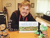 Tomáš Koňařík ukazuje nový kalendář s výběrem komiksů se zubatou žábou.