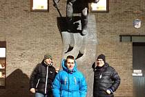 Běžci Atlasu Václav Sedláček (vlevo) a Michal Kautz (uprostřed) společně se svým ubytovatelem a průvodcem Hansem Staiem v Lillehammeru u památeční sochy lyžaře před muzeem.