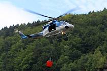 Policejní vrtulník hasí požár u Hřenska