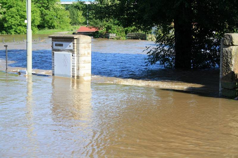 Velká voda začala zatápět město. Zábrany na pravém břehu zatím drží.