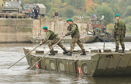 Třicet dva vojáků staví pontonový most na Labi
