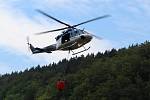Policejní vrtulník hasí požár u Hřenska