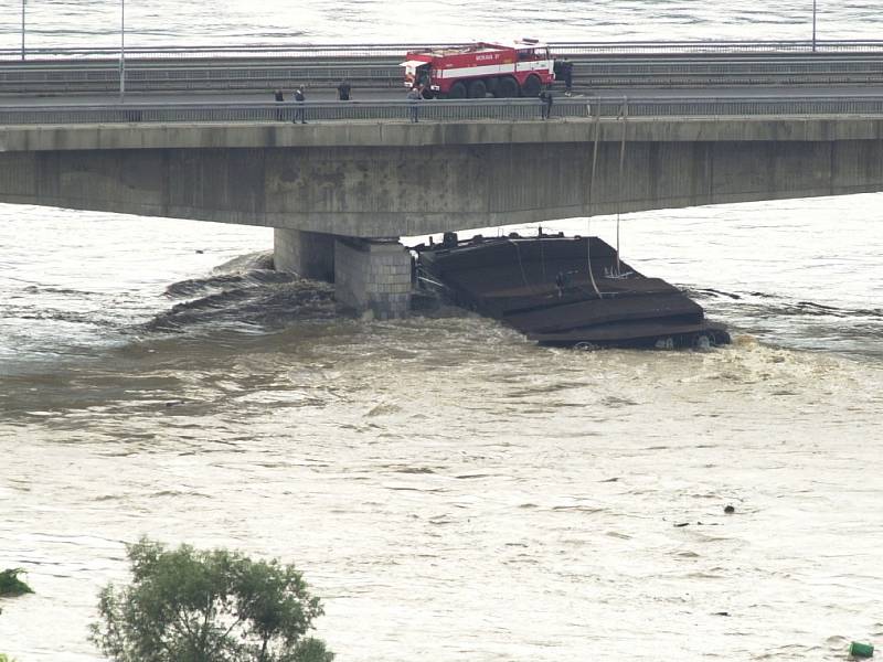 Při povodních se utrhlo pět lodí. Dvě z nich museli pyrotechnici  odstřelit. Na snímku je jedno z plavidel, které se zaseklo o pilíř Nového mostu v Děčíně. Jeho vrak po odstřelu 		nedostal z vody ani vyprošťovací tank a bylo nutné jej rozřezat.