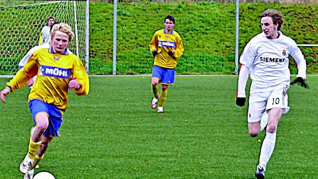 Autor prvního gólu v derby utkání, šluknovský Baloun (vpravo), se na snímku snaží dostihnout rumburského P. Pilka. Foto: Ladislav Čurgali  