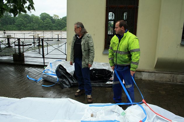 Pracovních technických služeb umisťují ochranu světel u dětského hřiště.