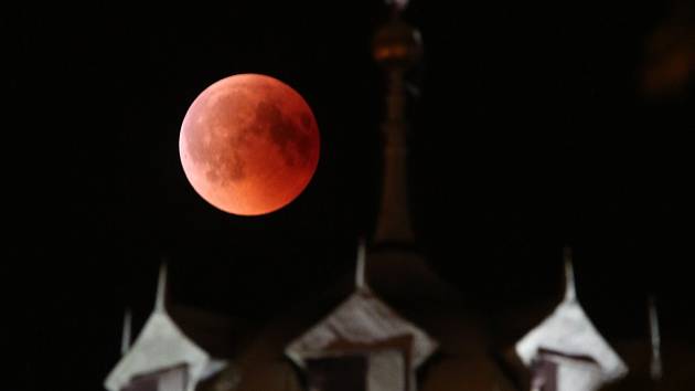 Pohled na úplné zatmění měsíce nad hradem Hazmburk a Litoměřiceme. Letošní oblačnost nepřála obdivovatelům vesmírného divadla a měsíc se objevil na oblože už téměř celý zahalený stínem.