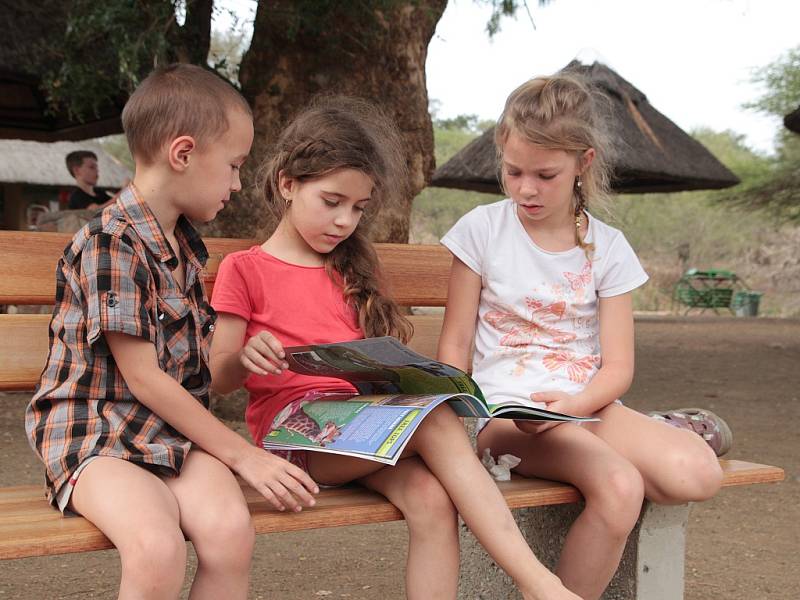 Děti si na picnic situ v Krugerově parku prohlížejí brožuru, se kterou pracovaly. 2016, JAR