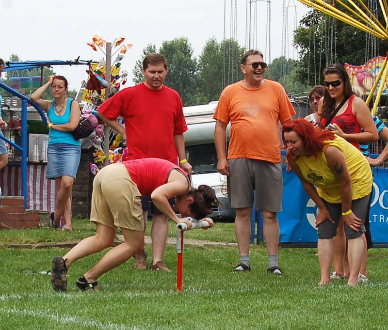 HONZÍKOVA ŘIDÍTKA. Při této disciplíně museli soutěžící s hlavou na řidítkách zdolat deset otoček kolem řidítek a poté doběhnout do cíle. Ženy a děti obíhaly řidítka jen pětkrát. 