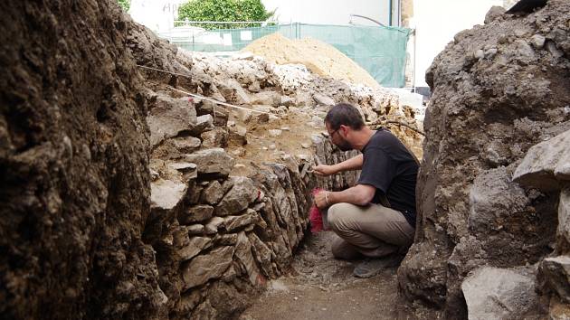 Archeolog Kryštof Derner zkoumá pozůstatky hradeb v místě, kde překonávaly příkop. 