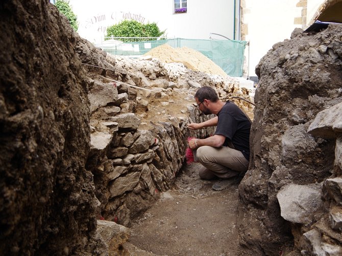 Archeolog Kryštof Derner zkoumá pozůstatky hradeb v místě, kde překonávaly příkop. 