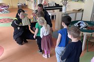 Strážníci předávají dárky dětem v chomutovské MŠ Kundratická.