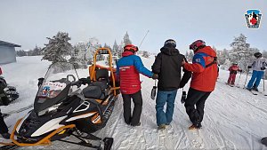 Záchranáři odvádějí zraněného snowboardistu z areálu na Klínovci.