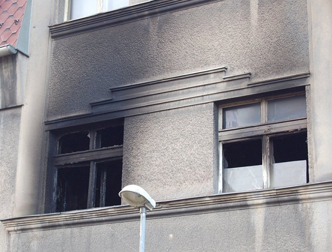 Okna v prvním patře domu v Sokolské ulici, kde hořelo.