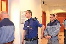 Policejní eskorta (na snímku), přivádí do soudní síně oba obžalované, Pavla Jaroše a Reného Bureše. Třetí obžalovaná Markéta Bartlová je stíhána na svobodě. 