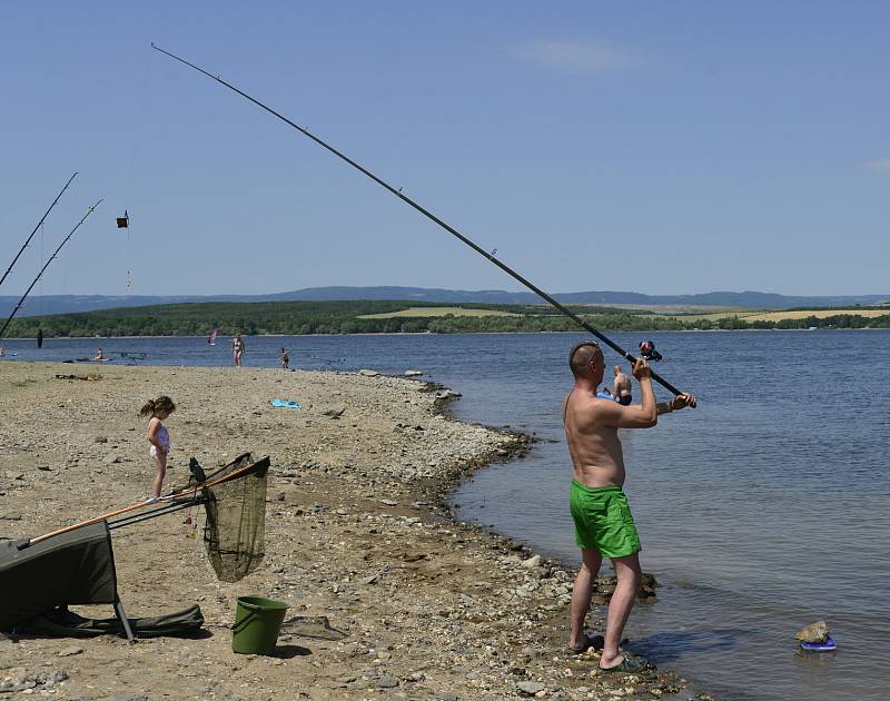 Voda v kempinku Nechranické přehrady byla ještě studená, ale to neodradilo několik odvážlivců, zvláště, když teplota venku atakovala 37 stupňů. Na břehu byli i rybáři.