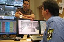 Starosta Jirkova Radek Štejnar diskutuje se strážníkem obsluhujícím kamerový systém ve „velíně“ místní městské policie, zda se na stěnu vejdou další monitory od kamer sledujících Ervěnice.