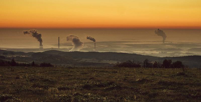 Pohled na severočeskou hnědouhelnou pánev s elektrárnami Prunéřov I, II a Tušimice v podzimním svítání doprovázeným mlhou v níže položených místech. Říjen 2017