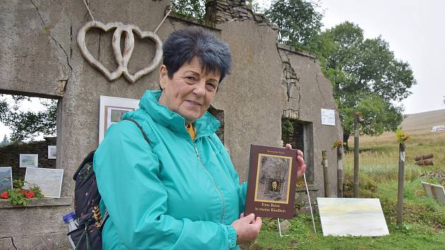 Rosemarie Ernst se svou knihou před pozůstatky rodného domu.