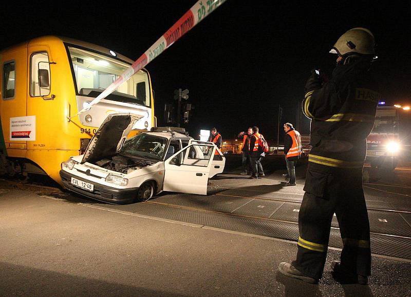 Auto zaklesnuté pod vlakem.