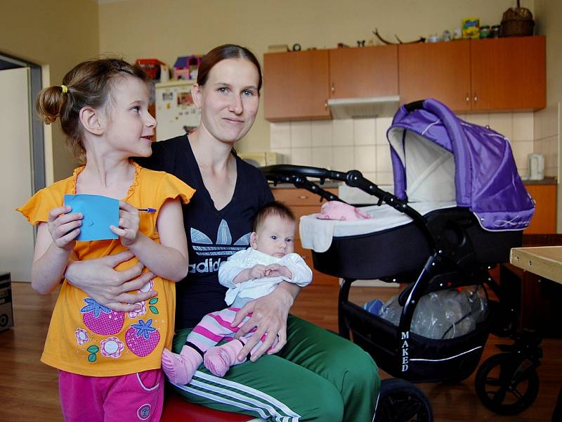 Jarmila Rjabcová (25) bydlí se svými dětmi a partnerem na té "správné straně". V bytě první kategorie. Na snímku s pětiletou Aničkou a dvouměsíční Adélkou. Ještě má čtyřletou Petrušku.