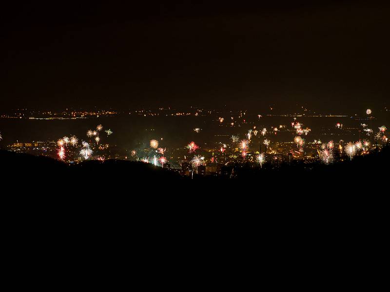 Pohled z hor na město Chomutov, které vítá mnoha ohňostroji příchod nového roku.