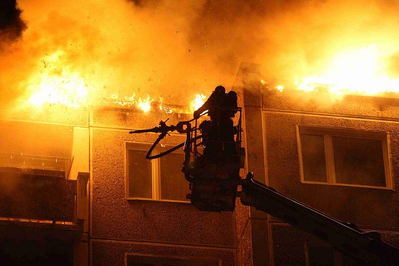 Hasiči zasahují u požáru střechy panelového domu v Jirkově u Chomutova