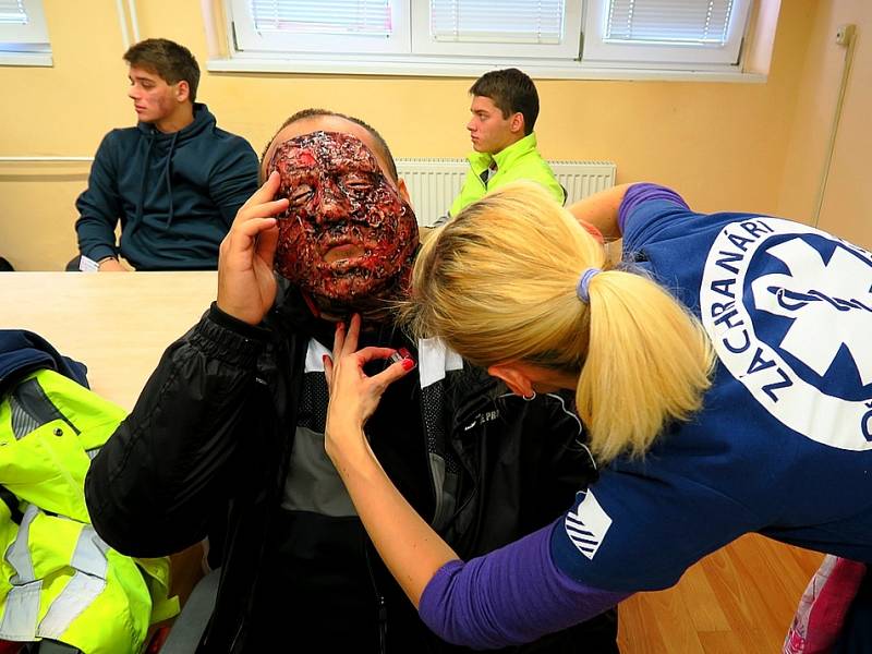 Veškerá zranění figurantů odpovídala realitě. Na snímku se jeden z nich pod rukami „maskérky“ z týmu záchranářů v České Kamenici přeměňuje v údržbáře se značně popáleným obličejem.