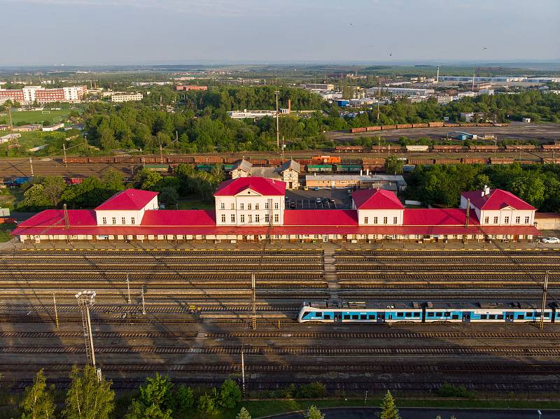 Pohled na historickou budovu vlakové nádraží v Chomutově a její kolejiště.