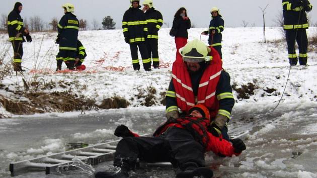 A JE VENKU. Dobrovolní hasiči z Mašťova si o víkendu vyzkoušeli, jak těžké je dostat na břeh člověka, který se právě ledem probořil do vody. 