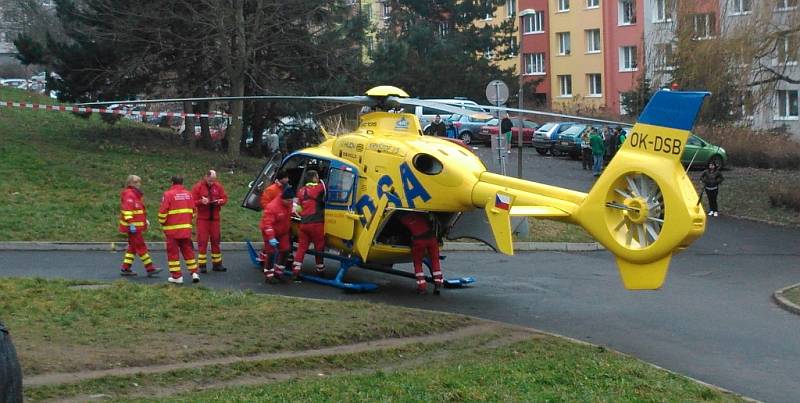 Záchranáři nakládají těžce zraněného muže do vrtulníku.