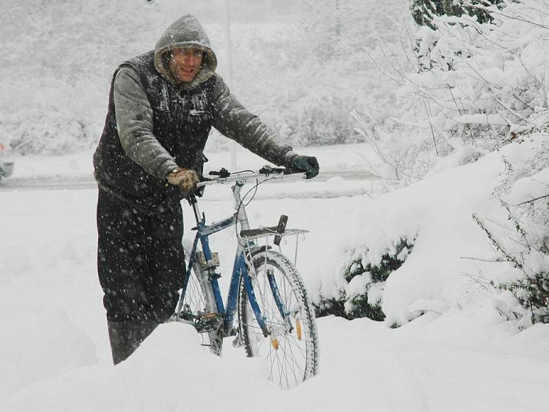 Klouže to autům, natož kolu:) Pěší cyklista si razil cestu sněhem pod chomutovským gymnáziem.