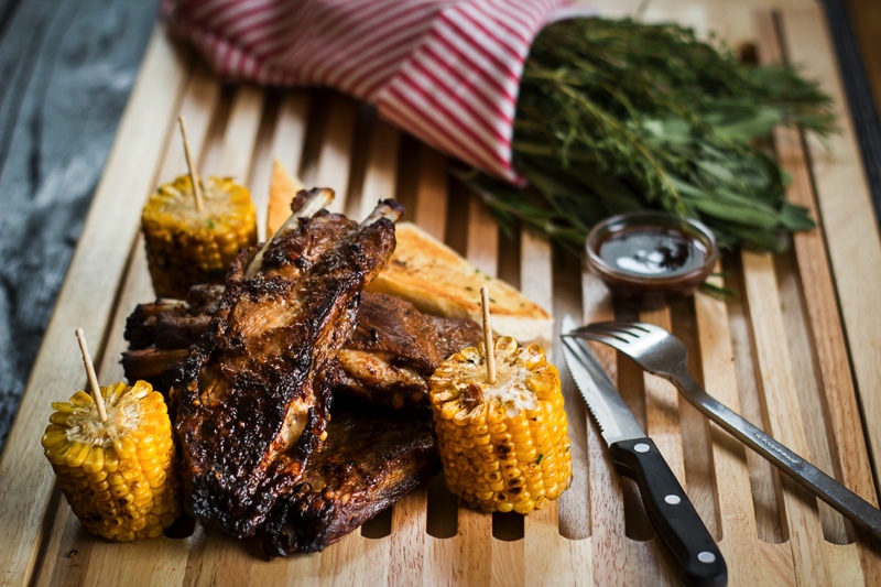 Vepřová žebra s barbecue omáčkou s pečeným kukuřičným klasem s bylinkovým máslem a bagetou